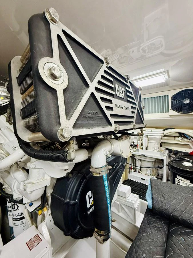 The image showcases the yacht's engine room featuring a CAT marine power unit. aboard KICKBACK Yacht for Sale