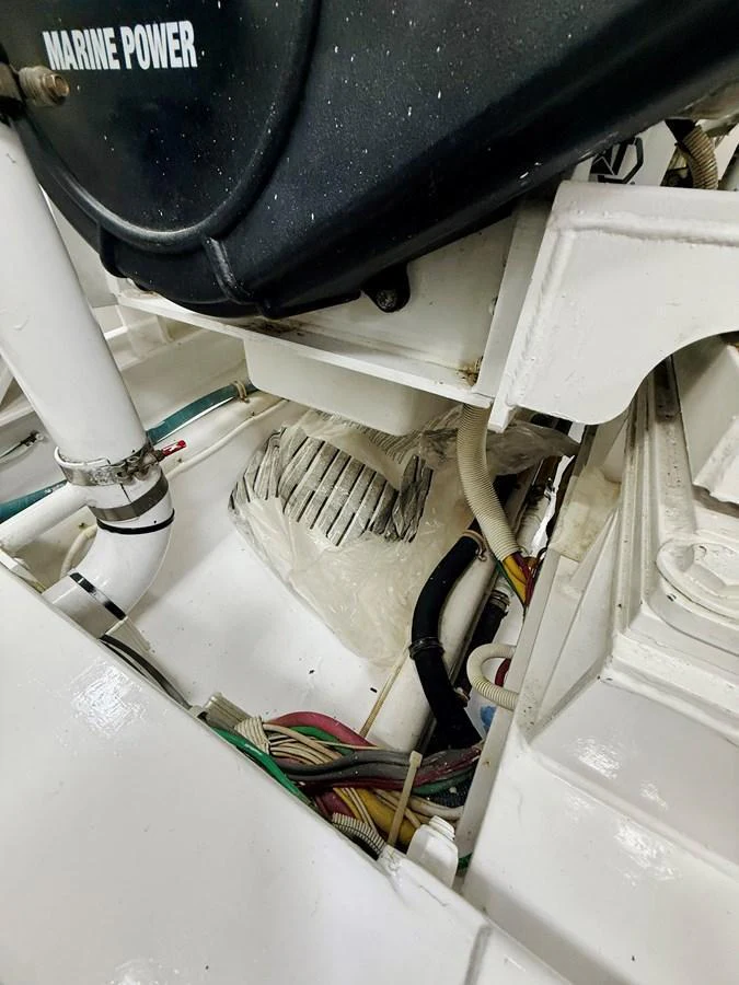 A close-up view of the yacht's engine compartment showcasing the mechanical components and wiring. aboard KICKBACK Yacht for Sale