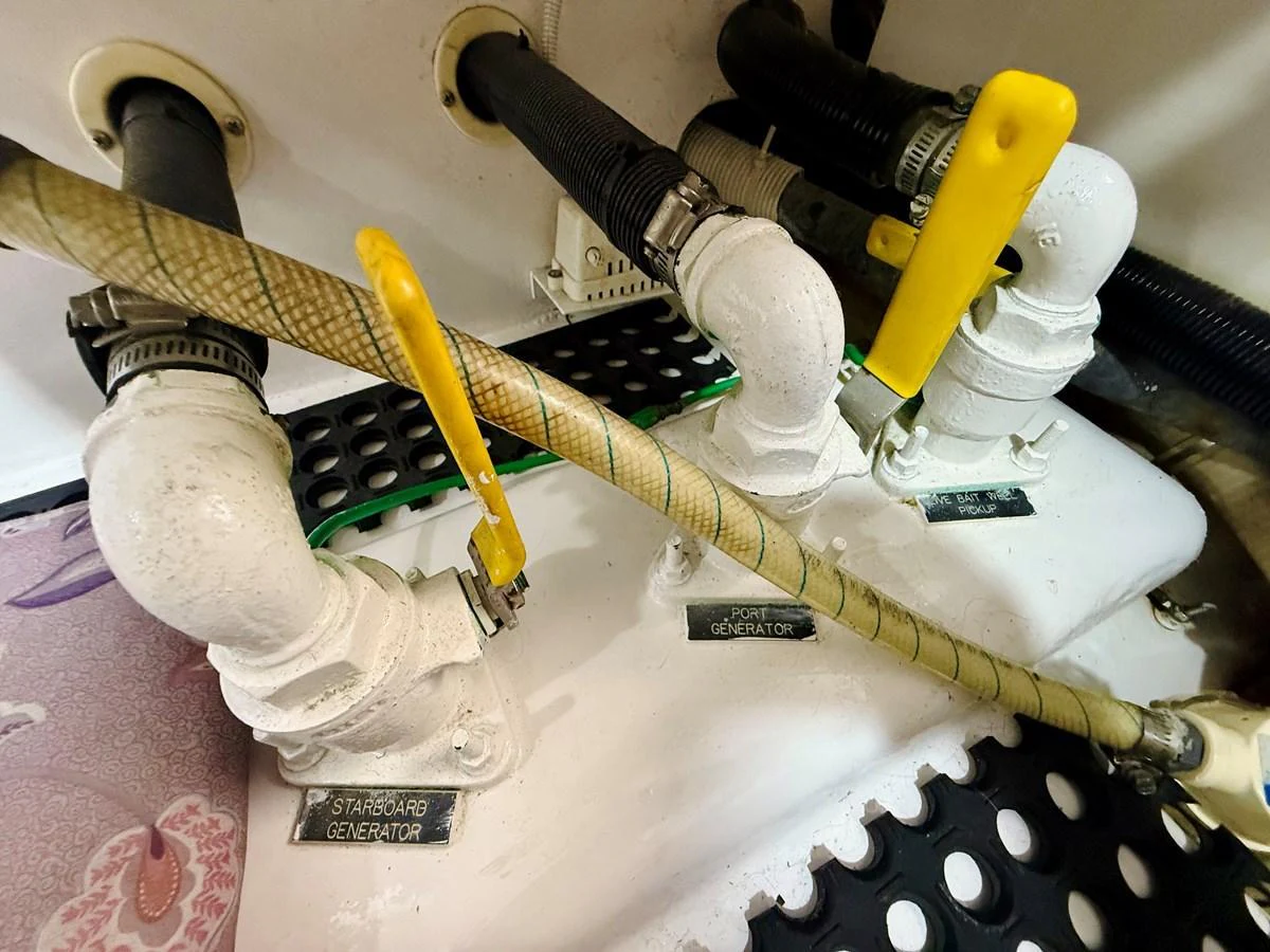 This image showcases the detailed plumbing and generator connections within the yacht's engine room. aboard KICKBACK Yacht for Sale
