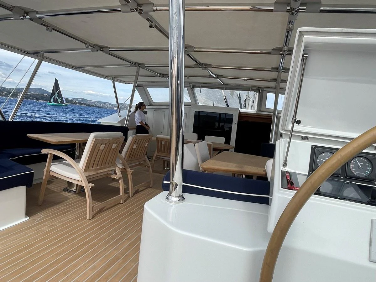The aft deck features comfortable seating and dining areas under a shaded canopy, perfect for relaxation and socializing. aboard MUMU Yacht for Sale