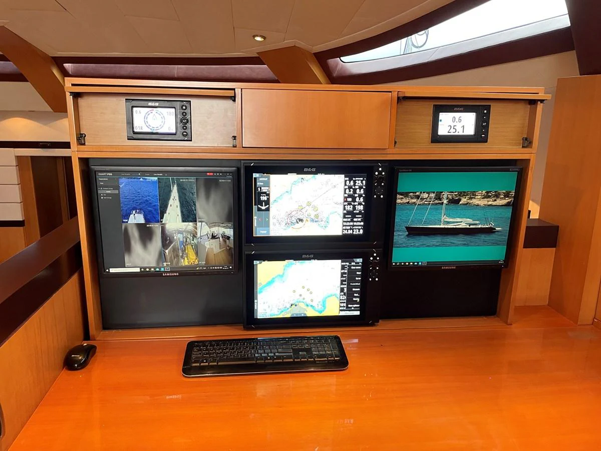 The helm station features multiple screens and navigation equipment, set against a sleek wooden console. aboard MUMU Yacht for Sale