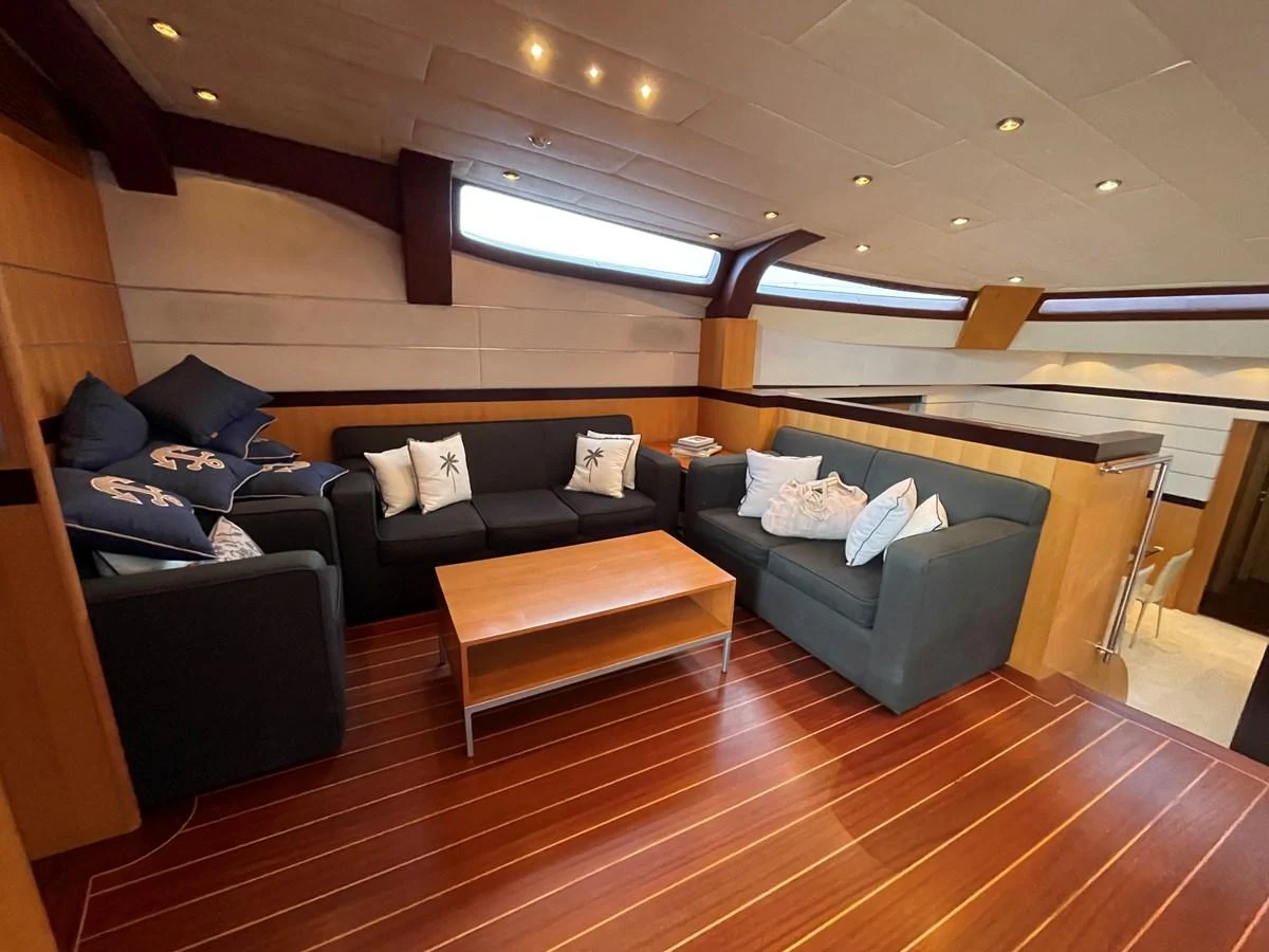 The salon features comfortable seating with elegant wood flooring and ample natural light. aboard MUMU Yacht for Sale