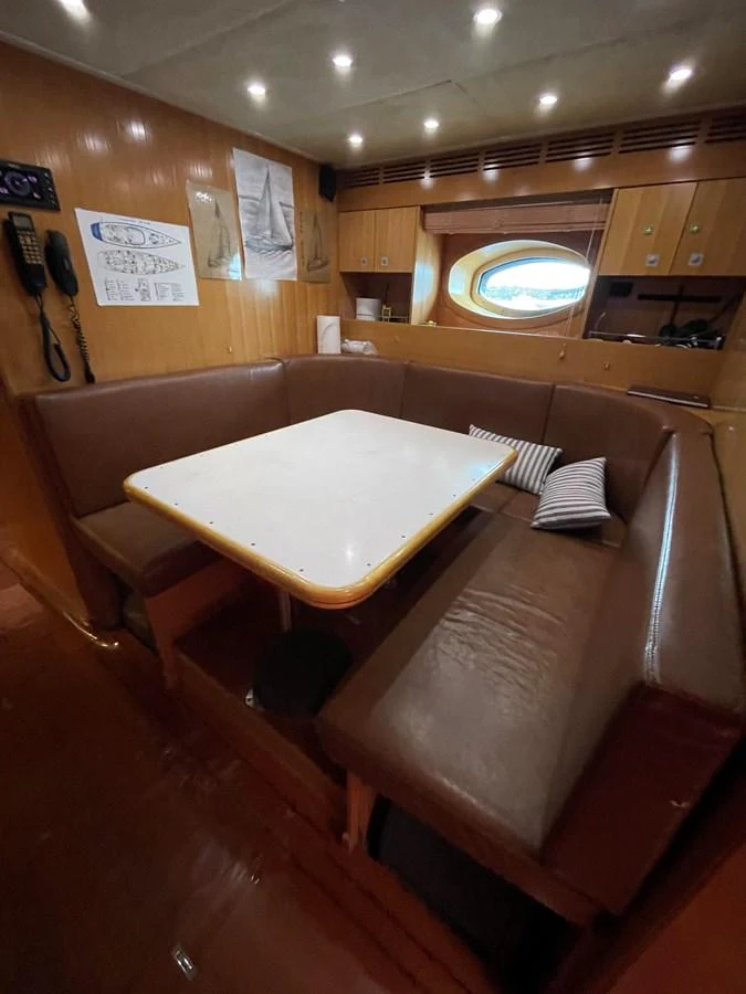 The yacht's cozy dining area features a comfortable seating arrangement with a central table, perfect for intimate meals. aboard MUMU Yacht for Sale