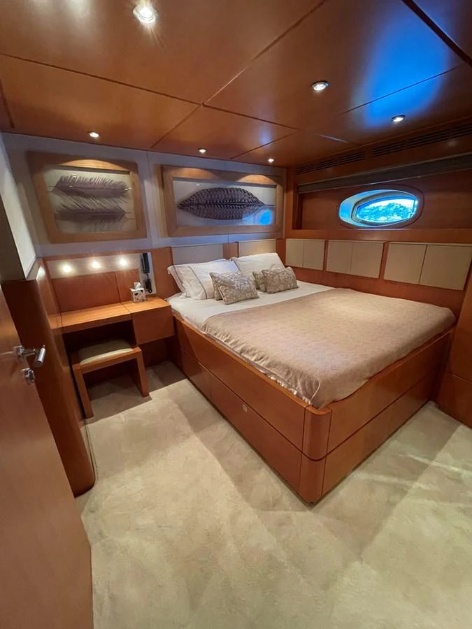 A cozy and elegantly designed stateroom featuring warm wood tones and soft lighting. aboard MUMU Yacht for Sale