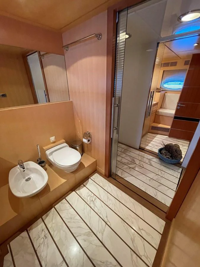 A well-appointed yacht bathroom with modern fixtures and a view into the adjacent cabin. aboard MUMU Yacht for Sale