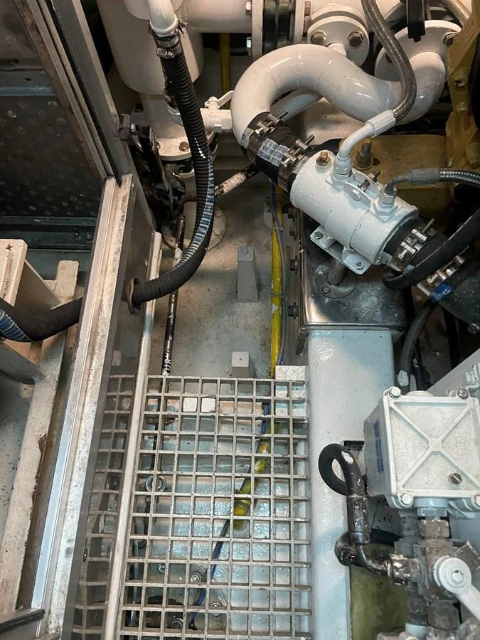 A close-up view of the yacht's engine room showcasing various mechanical components and piping. aboard MUMU Yacht for Sale