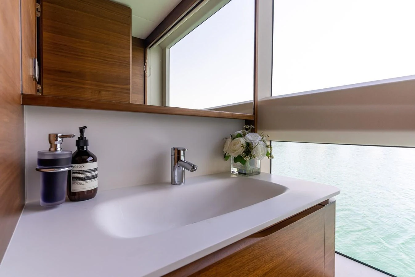 A sleek and modern yacht bathroom with a large window offering a view of the water. aboard SEMIA Yacht for Sale