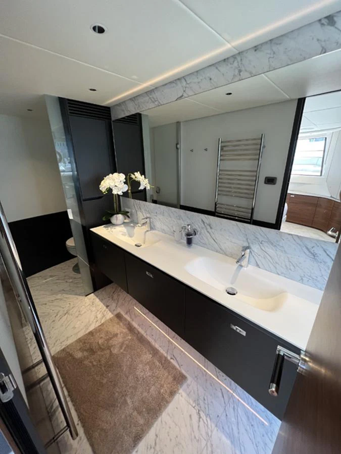 A luxurious yacht bathroom featuring dual sinks, marble countertops, and elegant fixtures. aboard SEMIA Yacht for Sale
