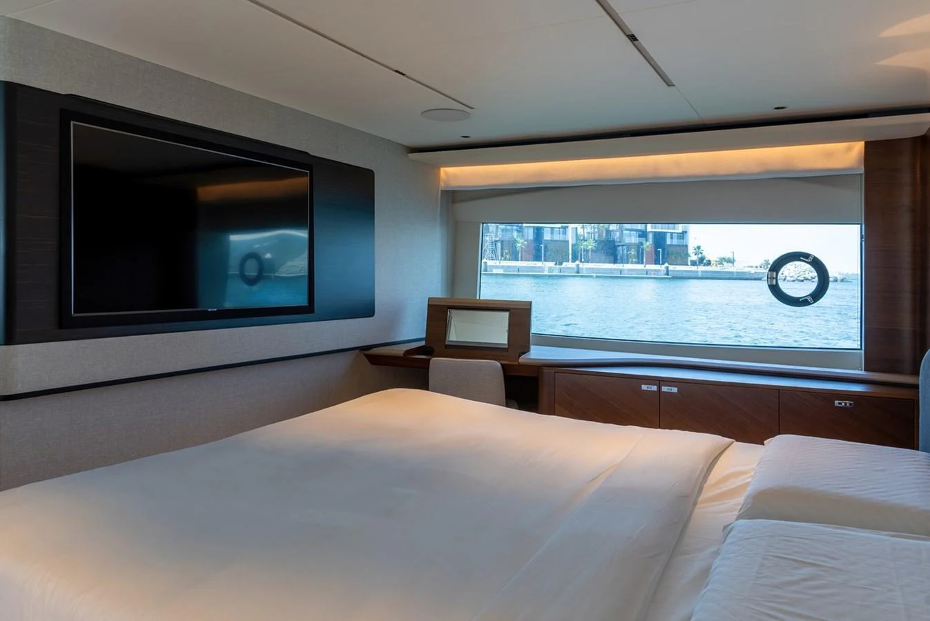 A luxurious stateroom featuring a large bed, a flat-screen TV, and a scenic window view. aboard SEMIA Yacht for Sale