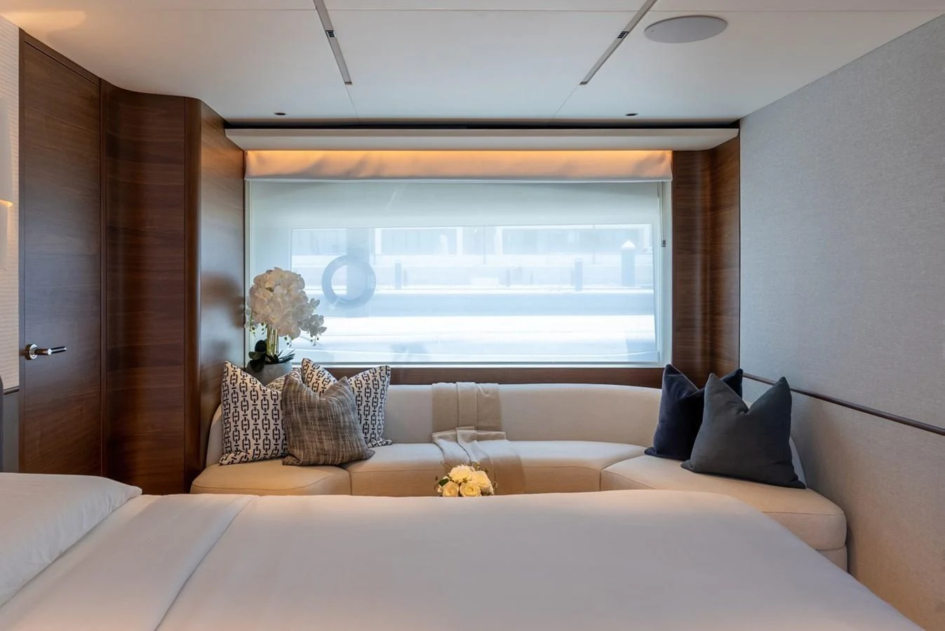 The stateroom features a cozy seating area with elegant decor and a large window providing ample natural light. aboard SEMIA Yacht for Sale