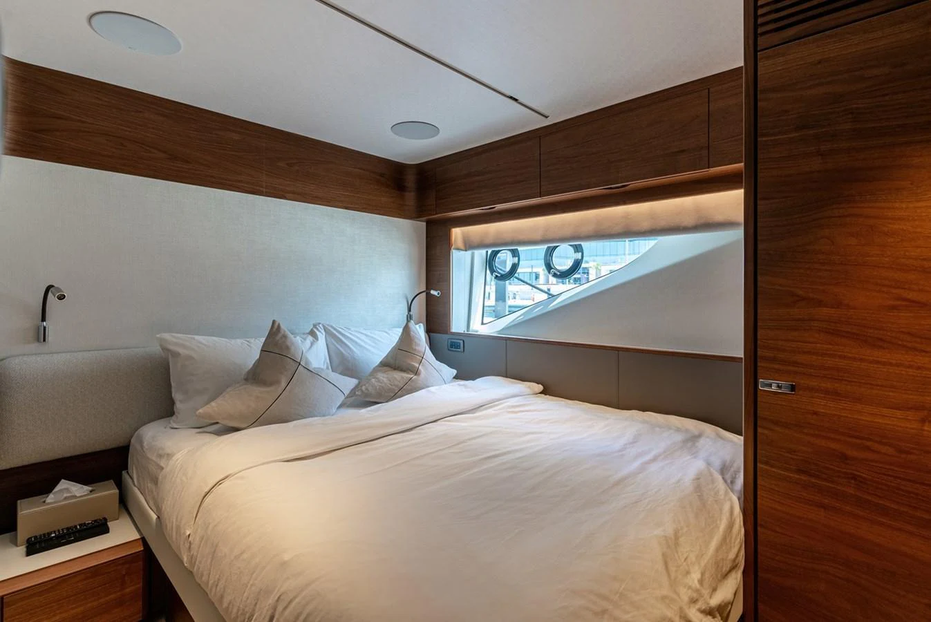 The stateroom features a cozy bed with plush pillows and a modern wooden finish. aboard SEMIA Yacht for Sale
