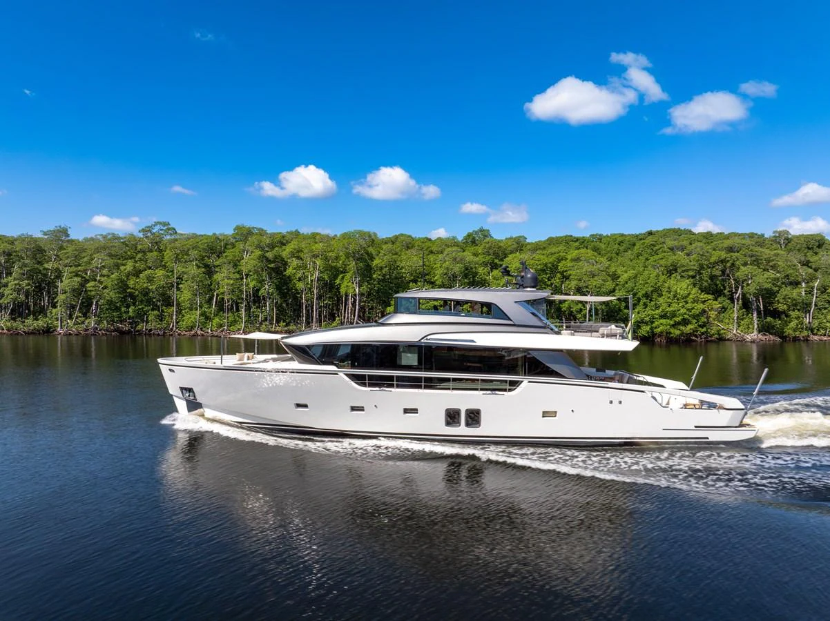 A sleek, modern yacht cruises gracefully on calm waters against a backdrop of lush greenery. aboard AIDA Yacht for Sale