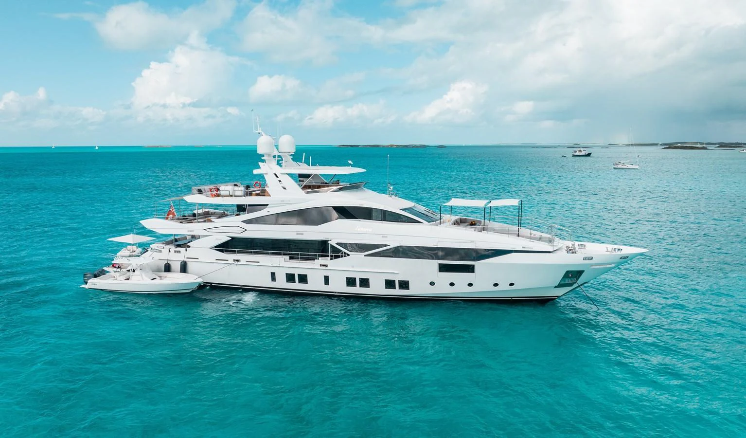 A sleek and modern yacht glides gracefully on turquoise waters under a partly cloudy sky. aboard EMINA Yacht for Sale