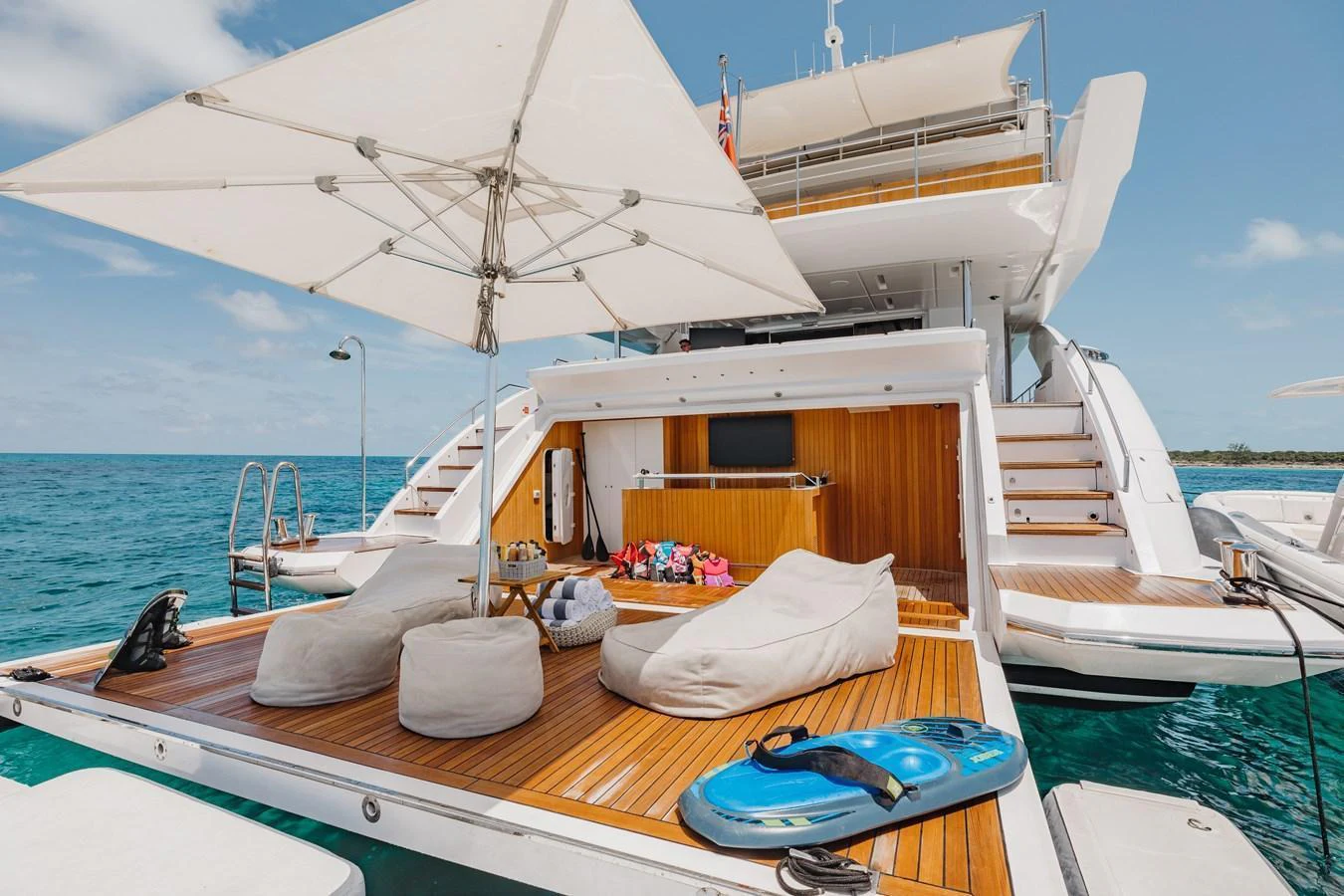 The aft deck features a luxurious lounging area with bean bags and a large umbrella, perfect for relaxation by the water. aboard EMINA Yacht for Sale