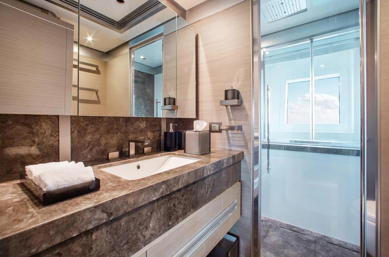 The yacht's bathroom features a sleek design with modern fixtures and a large window for natural light. aboard EMINA Yacht for Sale