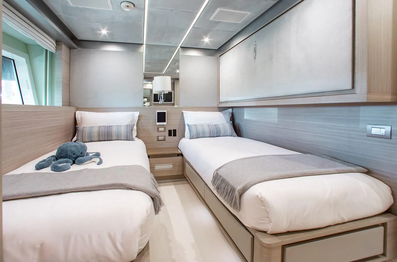 A modern twin stateroom with sleek design and cozy bedding. aboard EMINA Yacht for Sale