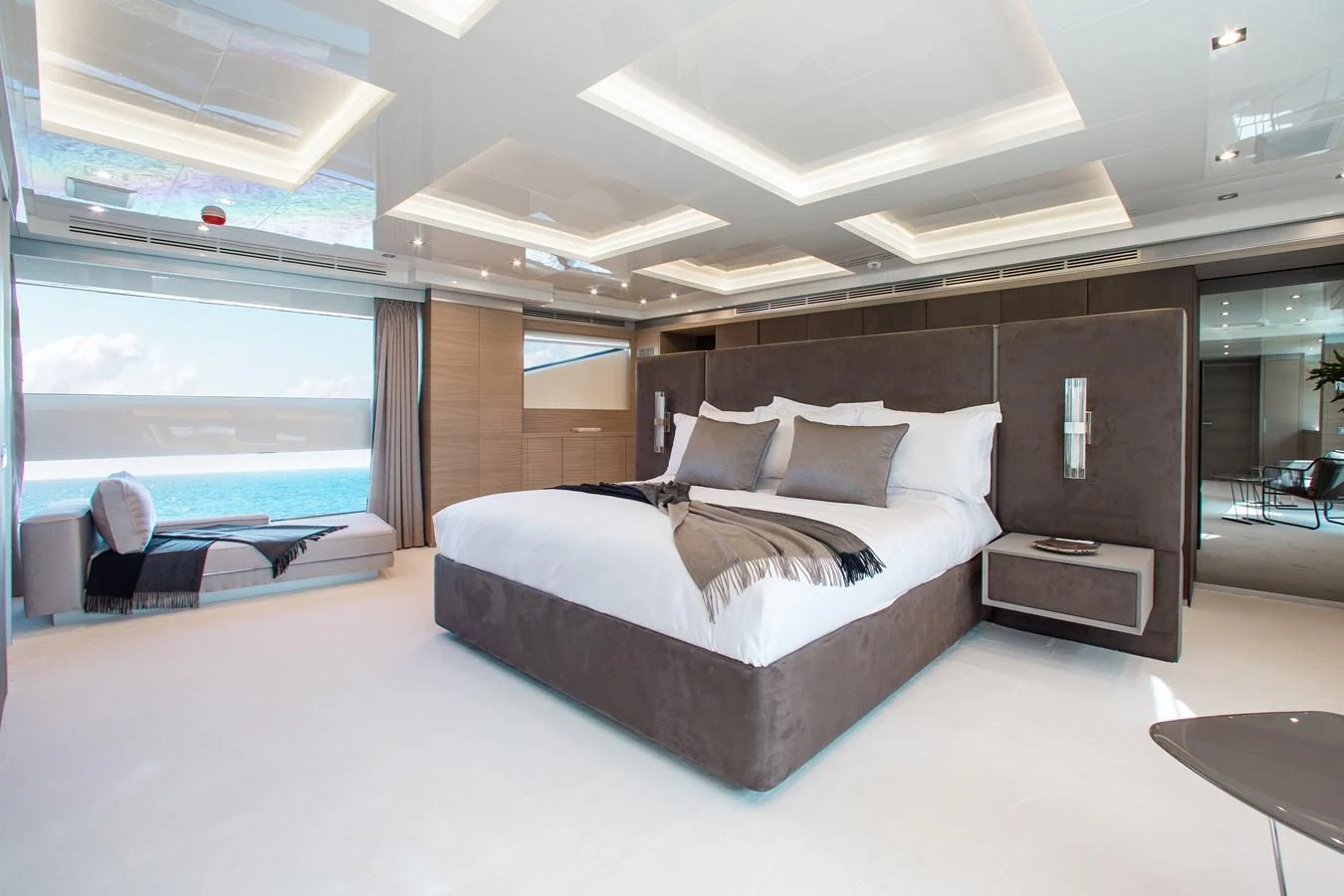 The master stateroom features a luxurious bed with a stunning ocean view through large windows. aboard EMINA Yacht for Sale
