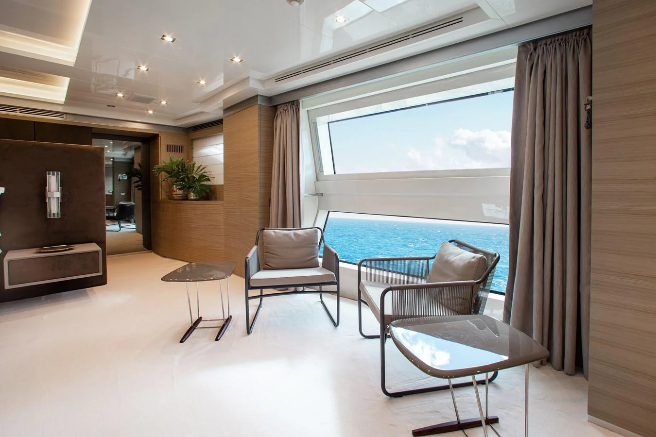 The yacht's interior features a modern seating area with large windows offering stunning ocean views. aboard EMINA Yacht for Sale