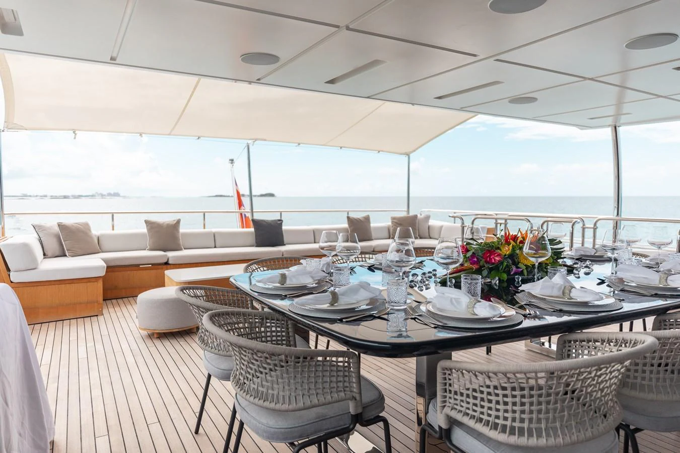 The aft deck features an elegant dining area with a stunning ocean view. aboard EMINA Yacht for Sale