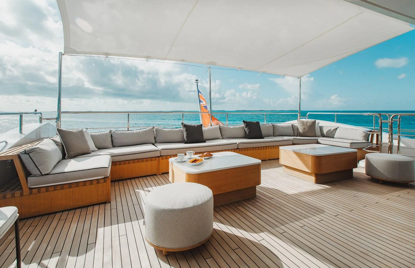 The aft deck features a spacious seating area with plush cushions and a stunning ocean view. aboard EMINA Yacht for Sale