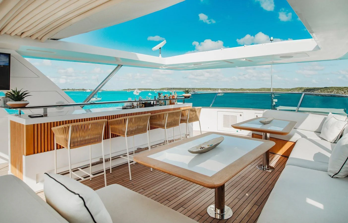 The flybridge offers a luxurious open-air dining and bar area with stunning ocean views. aboard EMINA Yacht for Sale