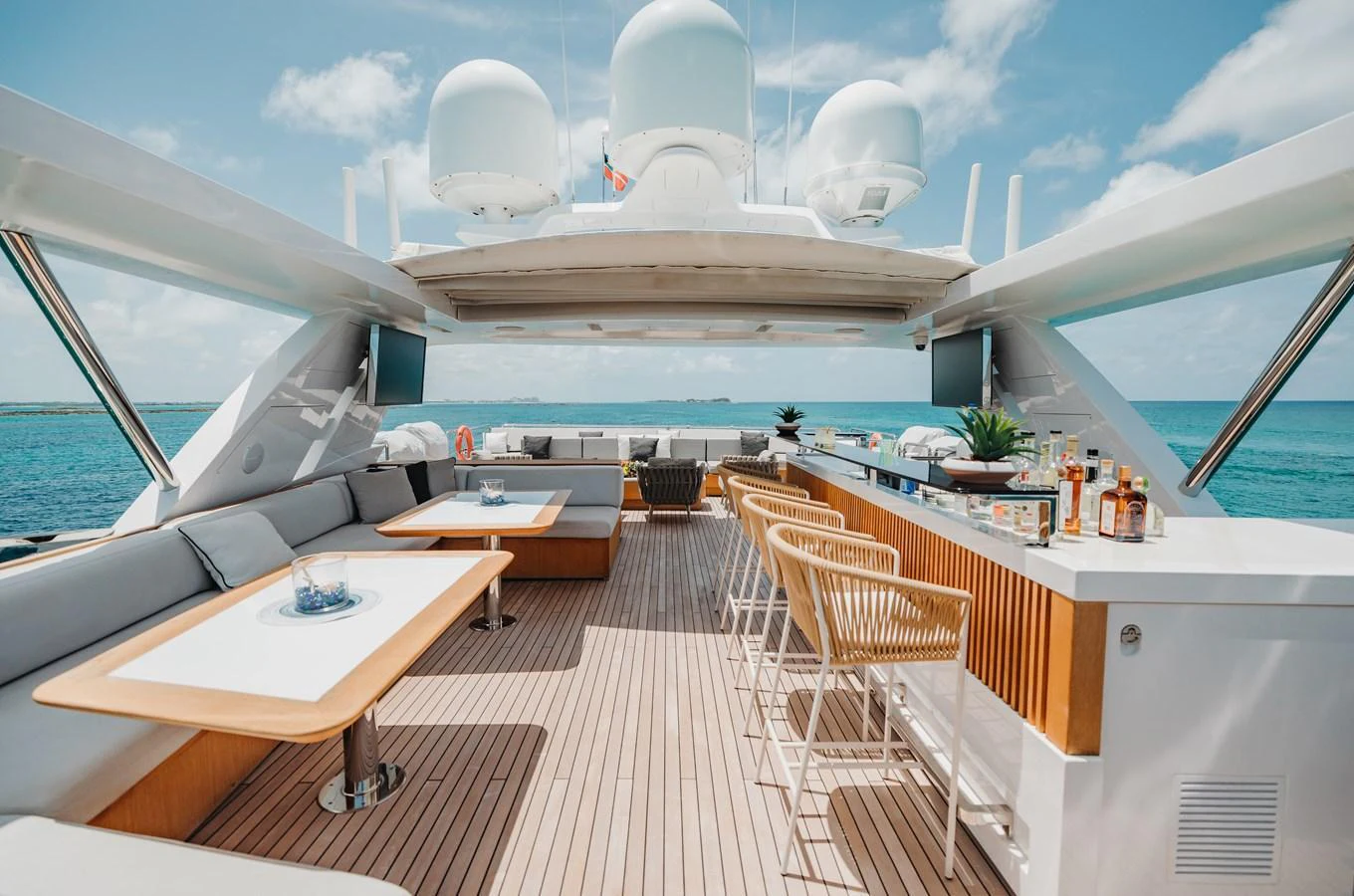 The flybridge features a luxurious bar and comfortable seating with stunning ocean views. aboard EMINA Yacht for Sale
