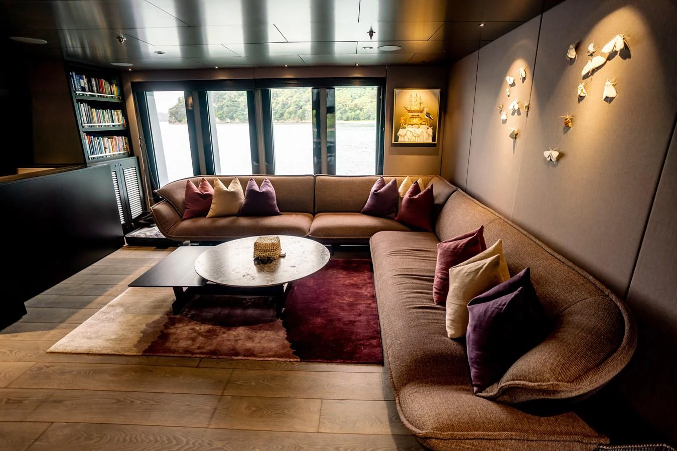 The salon features a spacious and inviting seating area with plush cushions and a view of the water through large windows. aboard THE BEAST Yacht for Sale