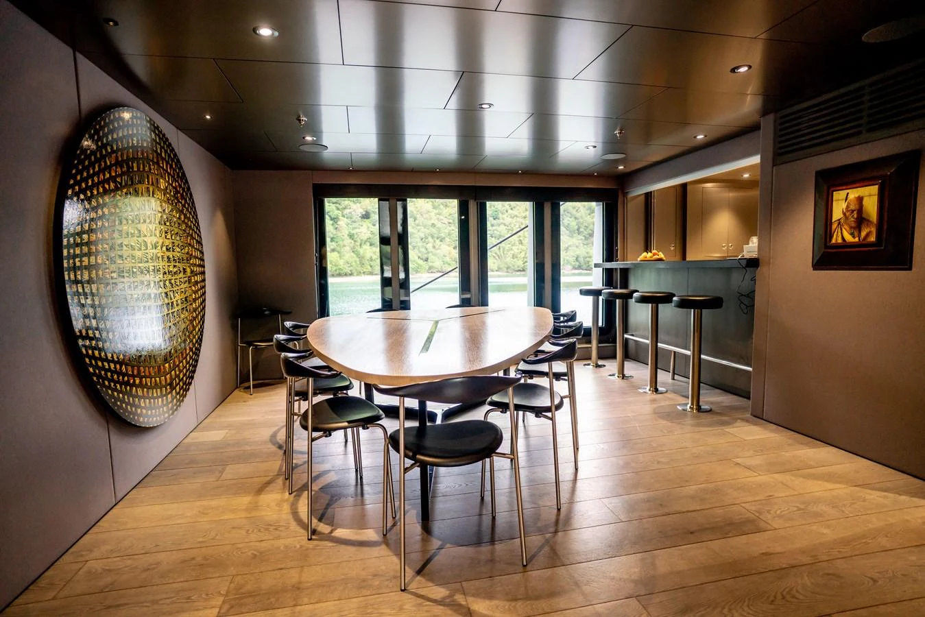 The yacht's dining area features a modern table with sleek chairs and a view of the surrounding water. aboard THE BEAST Yacht for Sale