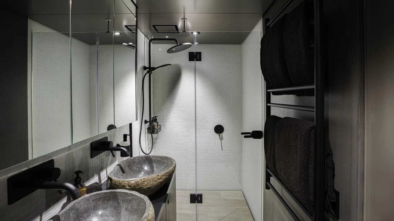 The yacht's bathroom features a modern design with dual stone sinks and a spacious glass-enclosed shower. aboard THE BEAST Yacht for Sale