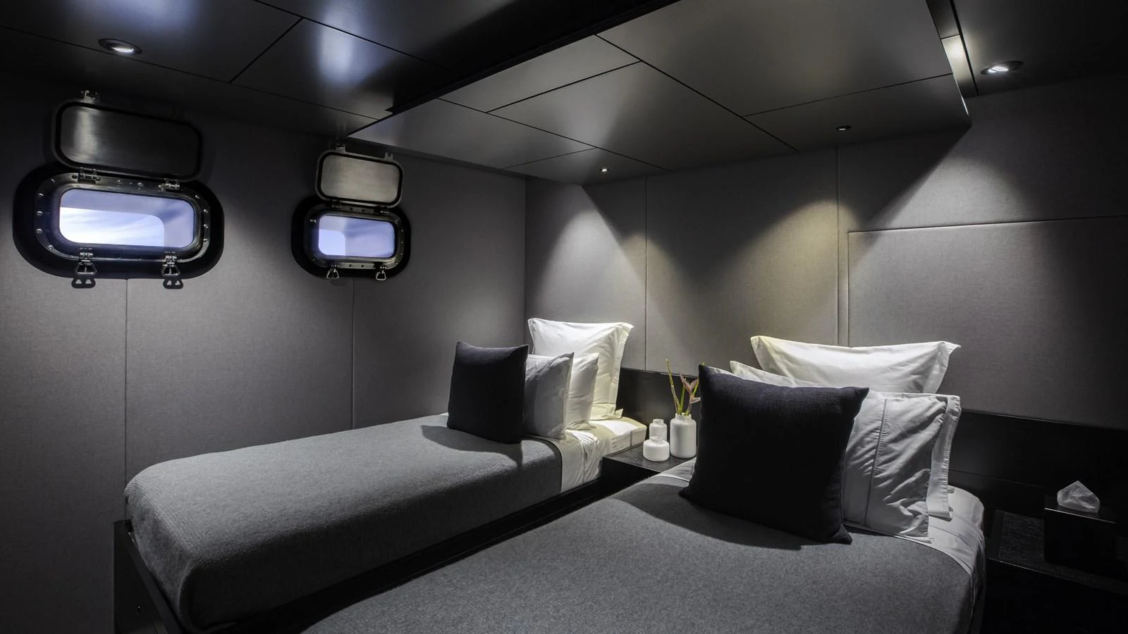 The twin stateroom features sleek, modern design with two single beds and ambient lighting. aboard THE BEAST Yacht for Sale