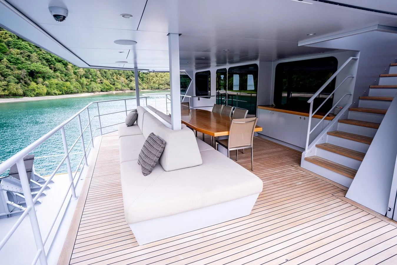 The aft deck features a spacious seating area with a dining table, perfect for outdoor relaxation and dining. aboard THE BEAST Yacht for Sale