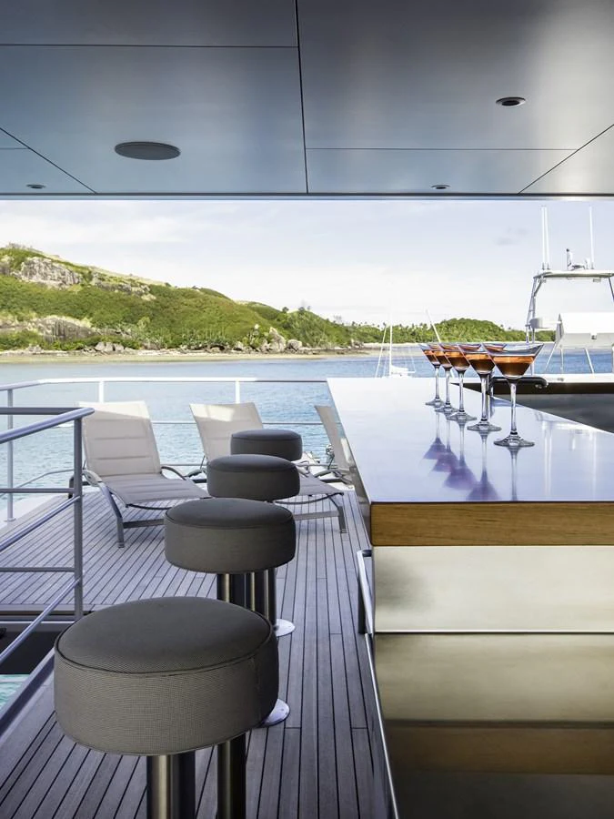 The yacht features a sleek bar area with a stunning view of the surrounding waters and landscape. aboard THE BEAST Yacht for Sale