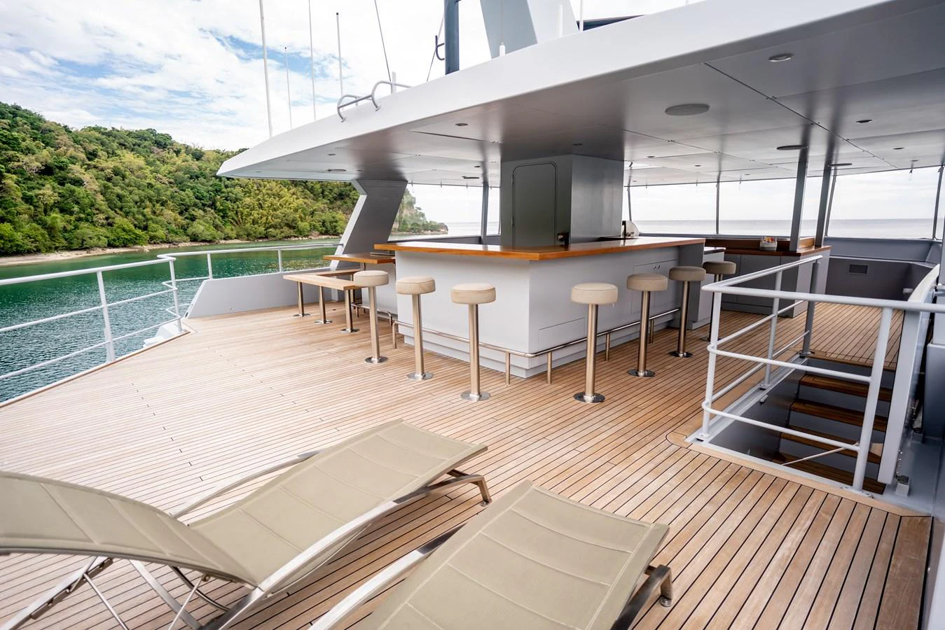 The sundeck offers a spacious area with bar seating and lounge chairs, perfect for relaxation and socializing. aboard THE BEAST Yacht for Sale