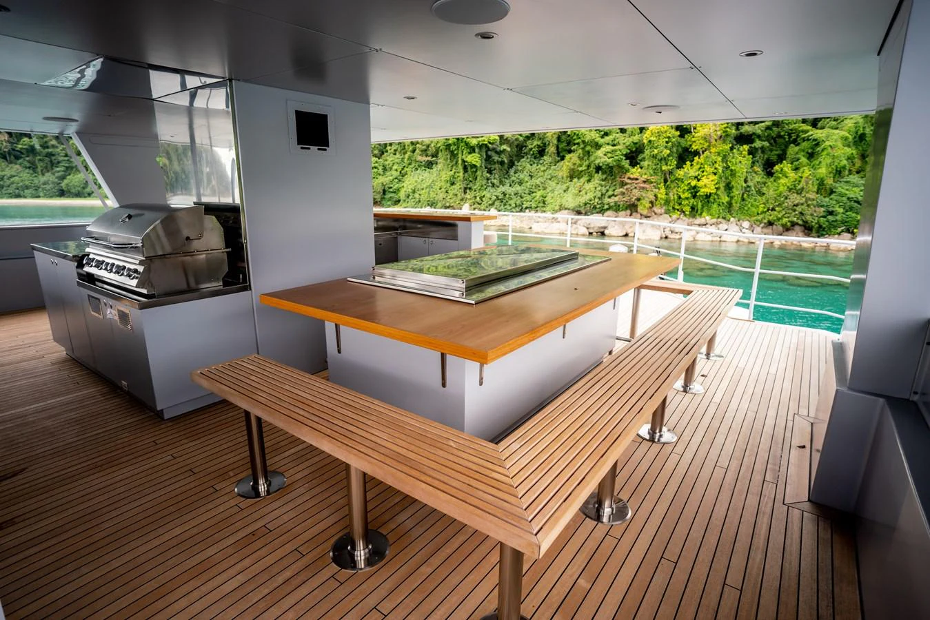 The aft deck features a spacious dining area with a large table and built-in benches, perfect for alfresco meals. aboard THE BEAST Yacht for Sale