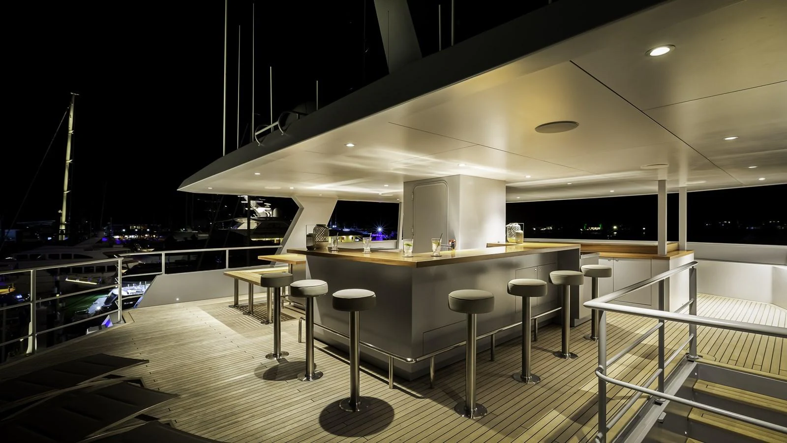 The sundeck features a sleek, modern bar area with ample seating, perfect for evening gatherings. aboard THE BEAST Yacht for Sale