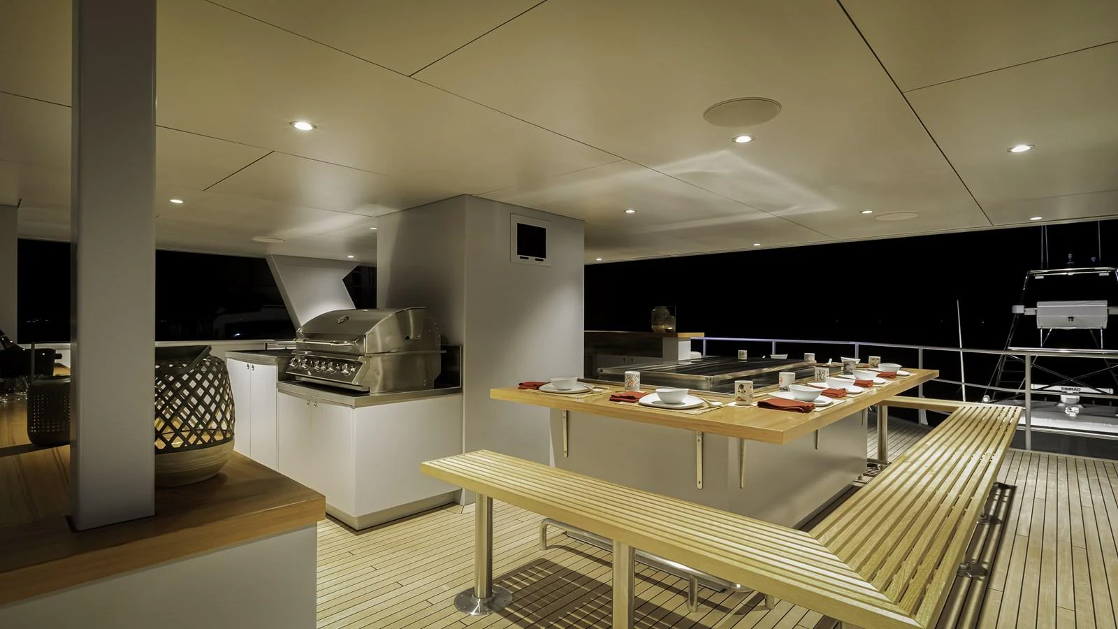 The yacht features a stylish outdoor dining area with a modern grill and ample seating. aboard THE BEAST Yacht for Sale