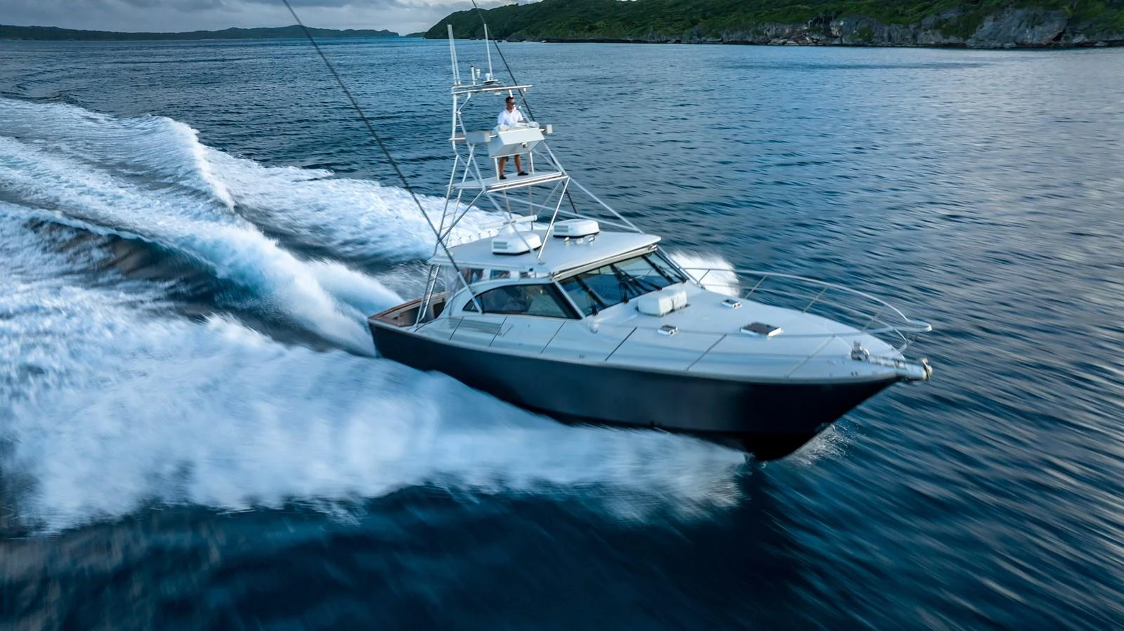 A sleek yacht cruises swiftly through the water, leaving a trail of white waves behind. aboard THE BEAST Yacht for Sale