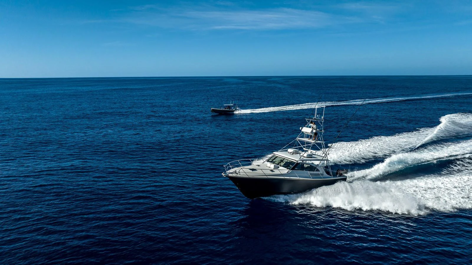 A sleek yacht cruises swiftly across the open ocean under a clear blue sky. aboard THE BEAST Yacht for Sale