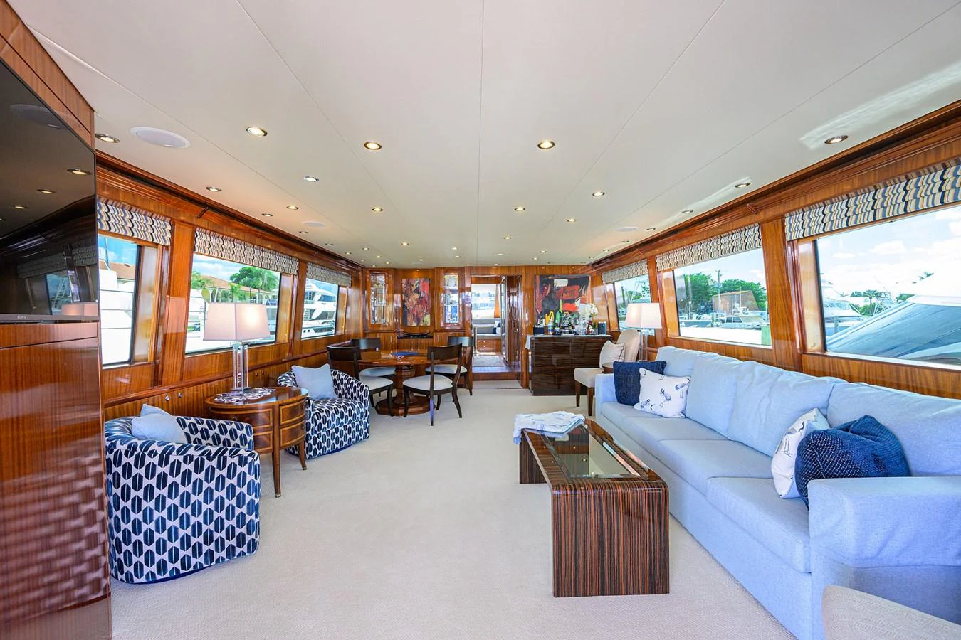 The spacious salon features elegant wood paneling, plush seating, and ample natural light. aboard SAPPHIRE Yacht for Sale