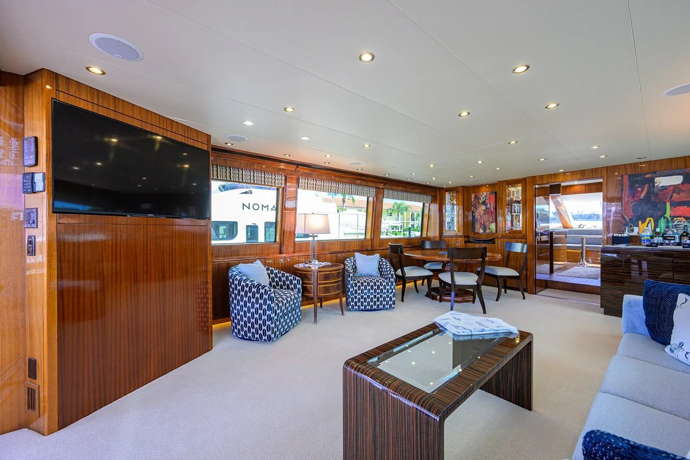 The salon features elegant wood paneling, plush seating, and a large flat-screen TV, creating a luxurious and comfortable living space. aboard SAPPHIRE Yacht for Sale