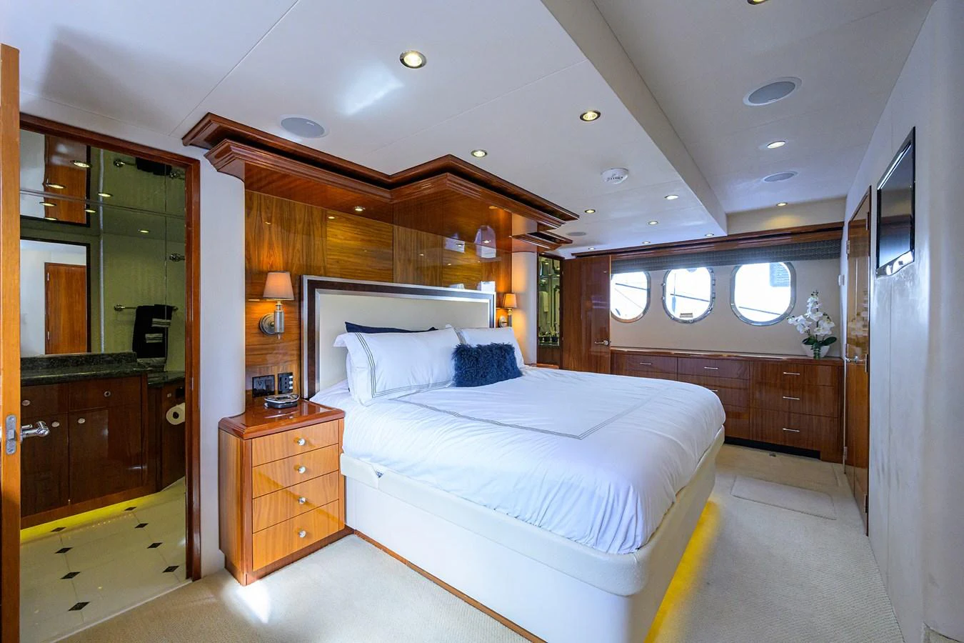 The master stateroom features a luxurious bed with elegant wood paneling and ample natural light from the porthole windows. aboard SAPPHIRE Yacht for Sale