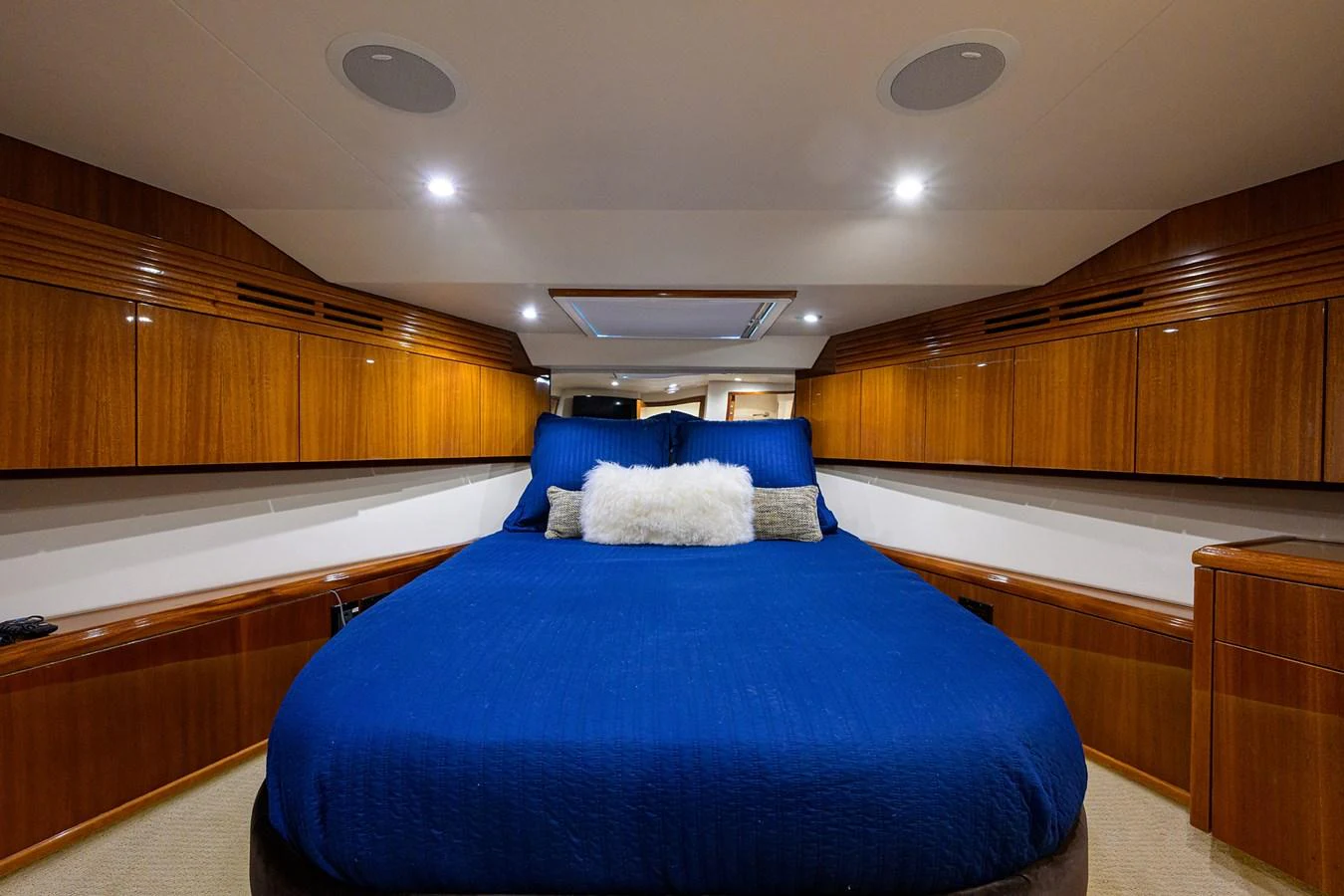 The stateroom features a luxurious bed with rich wooden cabinetry and modern lighting. aboard SAPPHIRE Yacht for Sale
