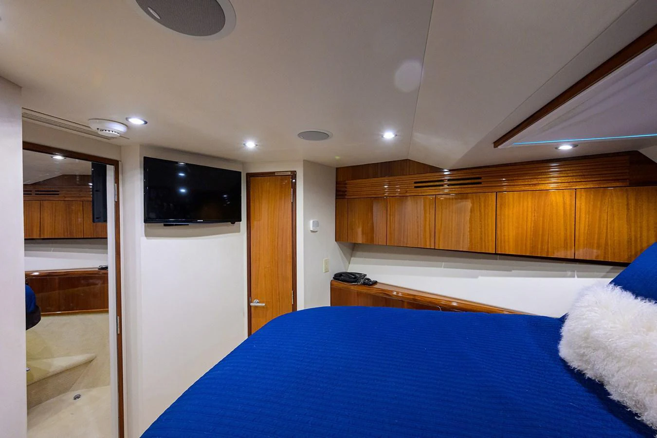 A cozy stateroom featuring a plush blue bedspread, wooden cabinetry, and modern amenities. aboard SAPPHIRE Yacht for Sale