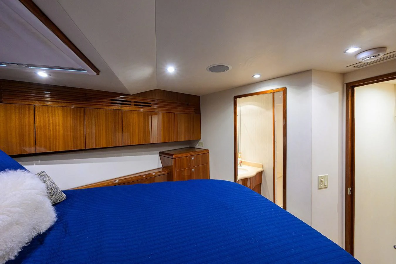 The stateroom features a cozy bed with rich wooden cabinetry and an en-suite bathroom. aboard SAPPHIRE Yacht for Sale