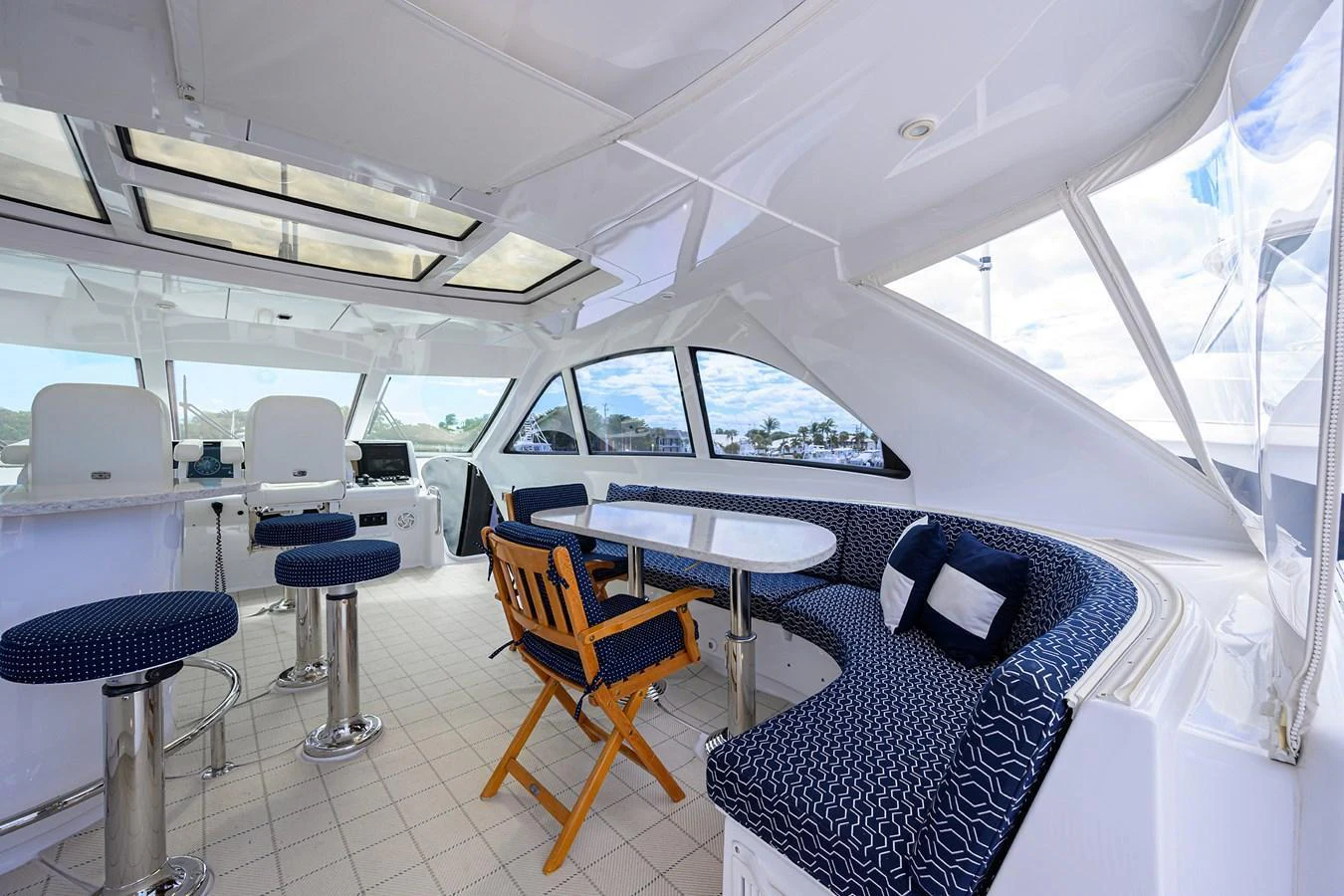The yacht's salon features a spacious seating area with a table and bar stools, offering a comfortable and stylish environment. aboard SAPPHIRE Yacht for Sale