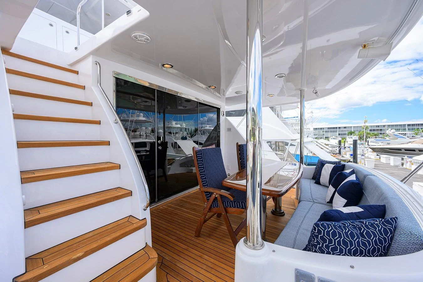 The aft deck features a comfortable seating area with a table and stairs leading to the upper deck. aboard SAPPHIRE Yacht for Sale