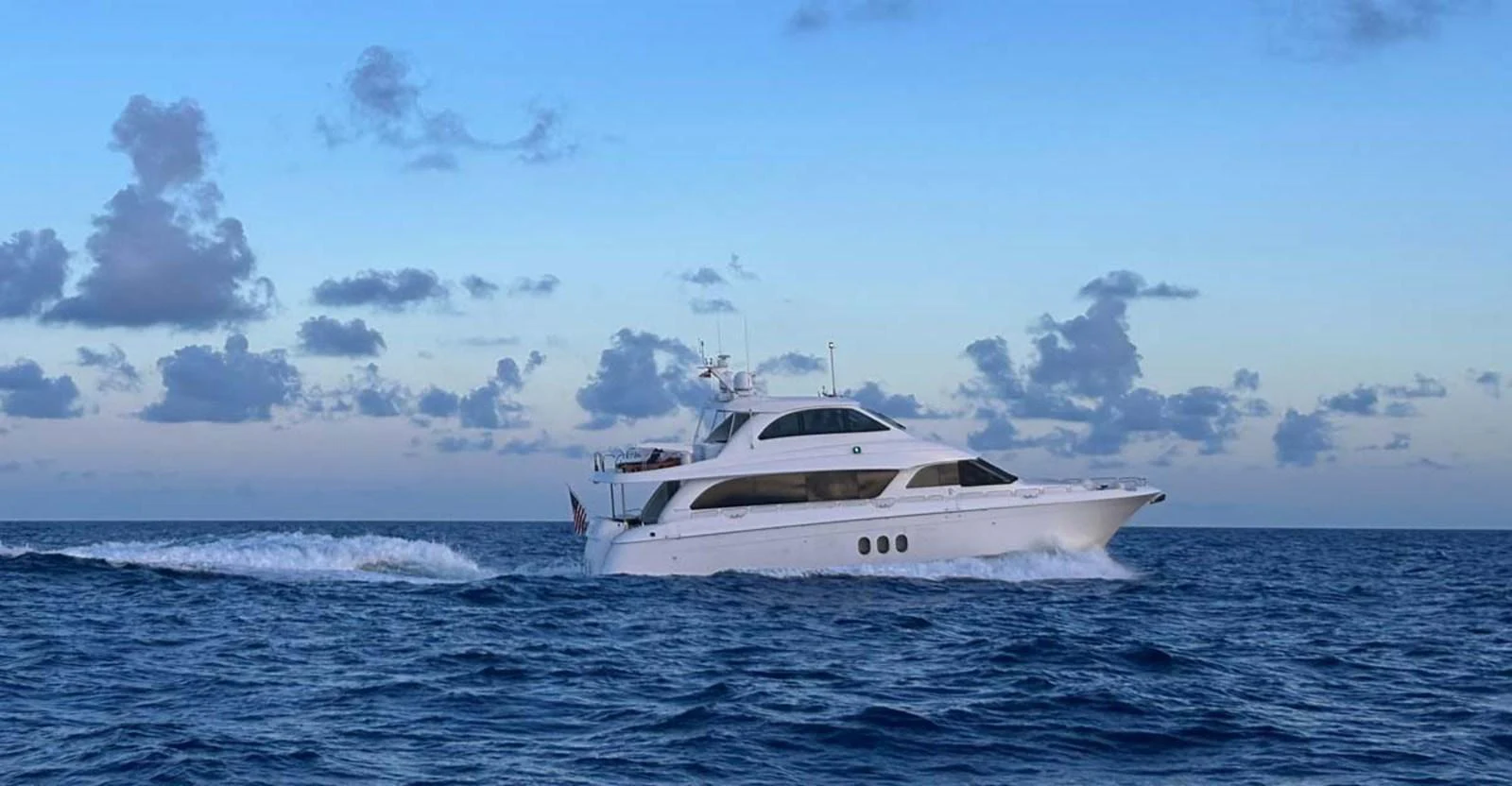 A sleek yacht cruises through the open sea under a serene sky. aboard SAPPHIRE Yacht for Sale