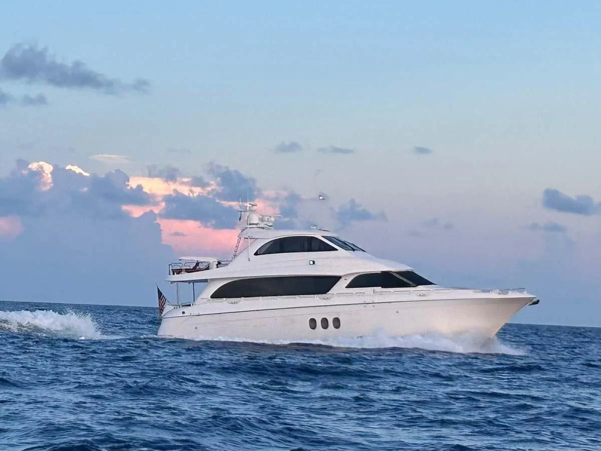 A sleek white yacht cruises gracefully on the open sea against a serene sunset backdrop. aboard SAPPHIRE Yacht for Sale