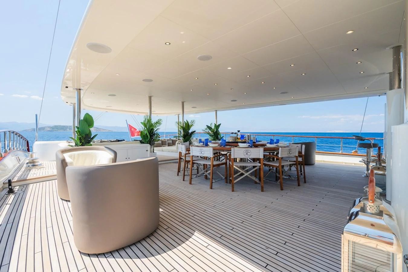 a room with a table chairs and a large body of water aboard THE LANGLEY Yacht for Sale