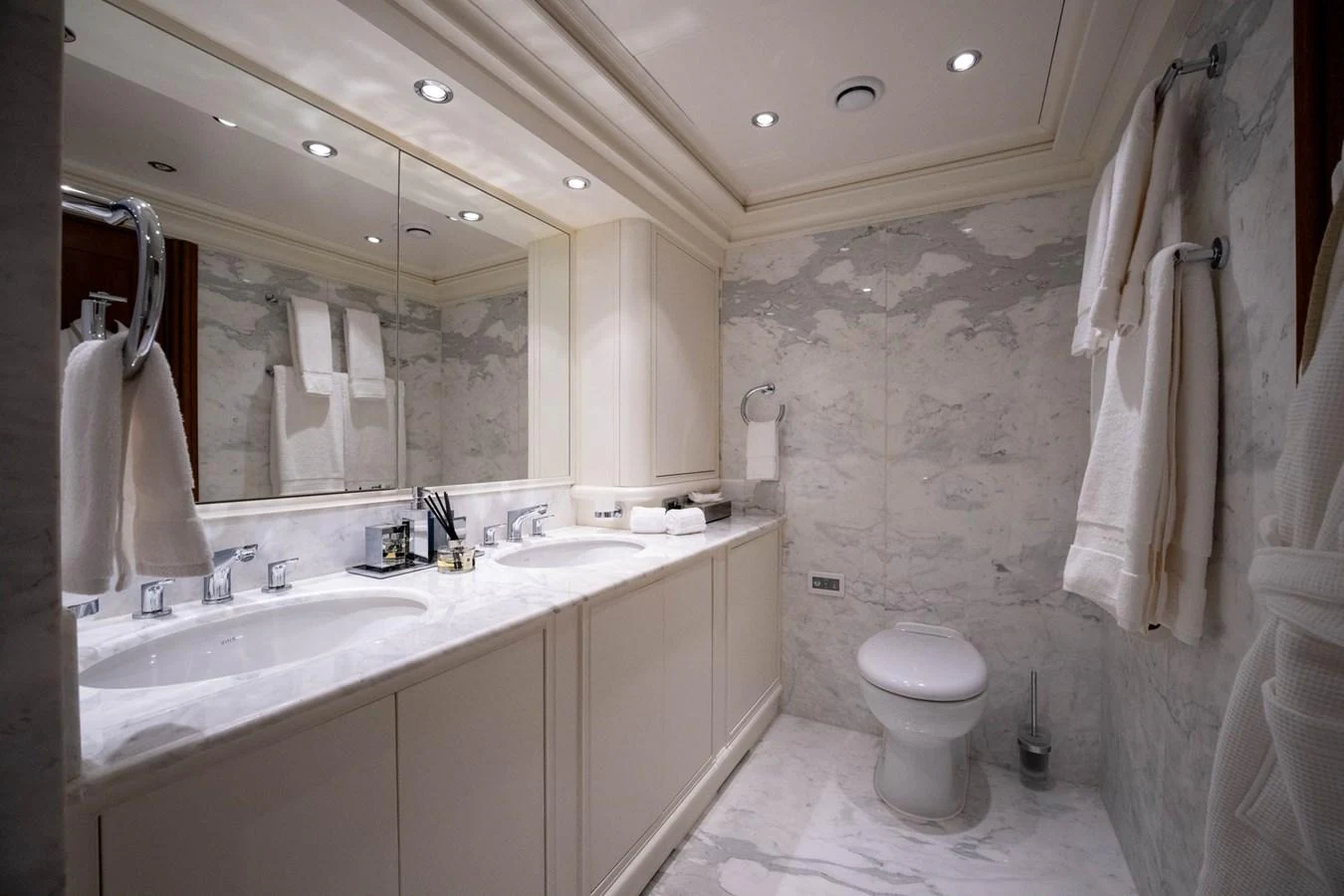 a bathroom with a toilet sink and a mirror aboard THE LANGLEY Yacht for Sale